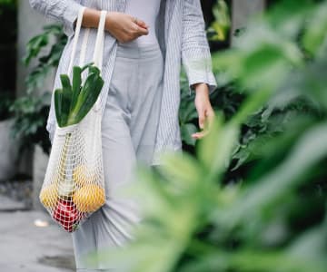 A women carries fruit in a bag